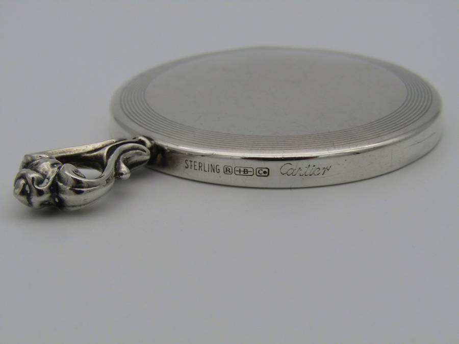 A sterling silver hand mirror by Cartier. Circa 1920s.