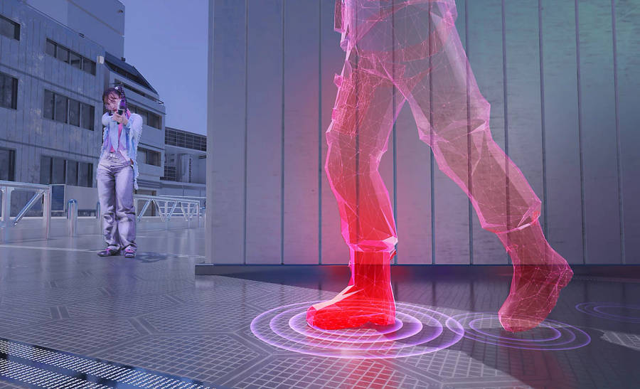 A person holding a plastic gun in a computer game world aiming at a 3D model with rings around the foot for sound