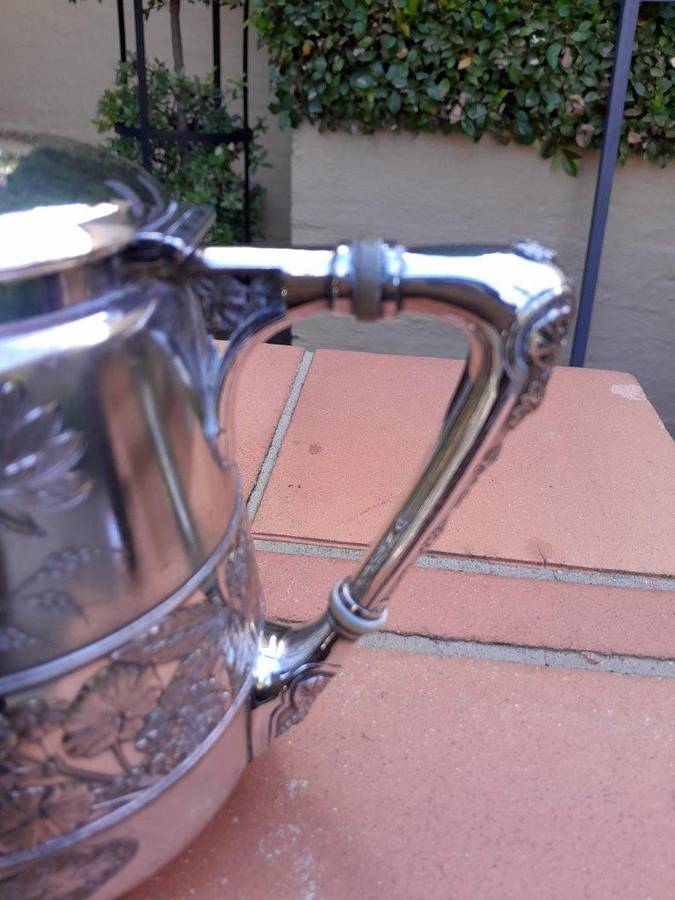 A Silver-Plated Tea Pot With Floral Designs