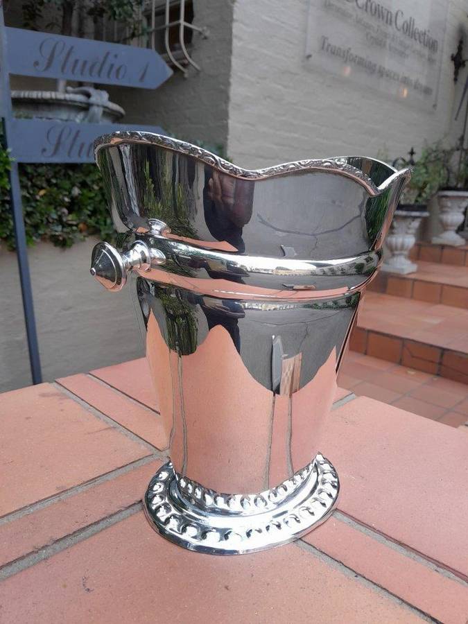 A Silver-Plate Ice Bucket  The Wavy Rim Above A Tapering Body, Applied Opposing Handles, Raised ...
