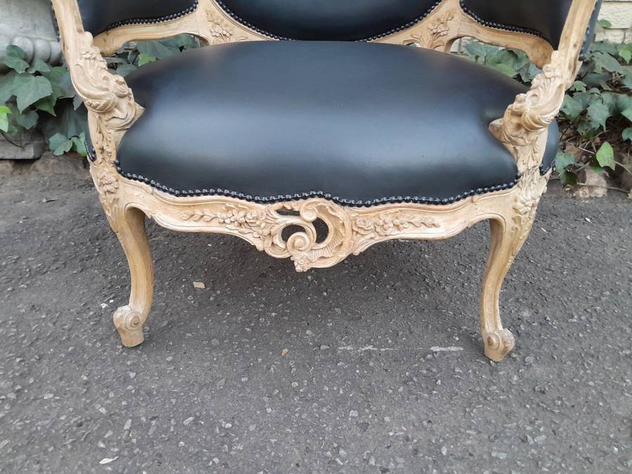 A 20TH Century French Style Bergere Style Carved Chair in a Contemporary Natural Wood Finish upho...