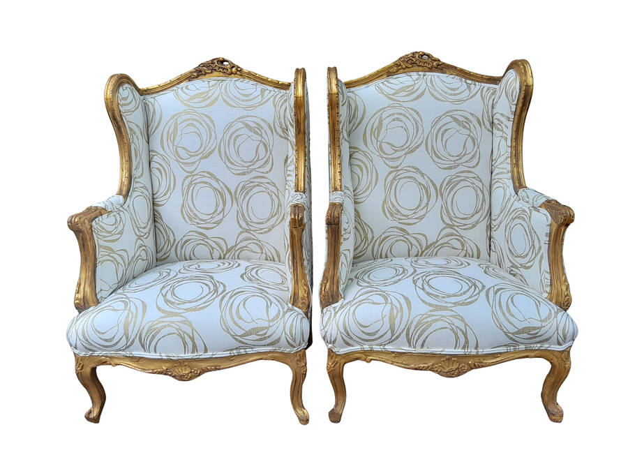 A French Style Pair of Hand Gilded Carved Wingback Chairs Upholstered in a Custom Made for The Cr...