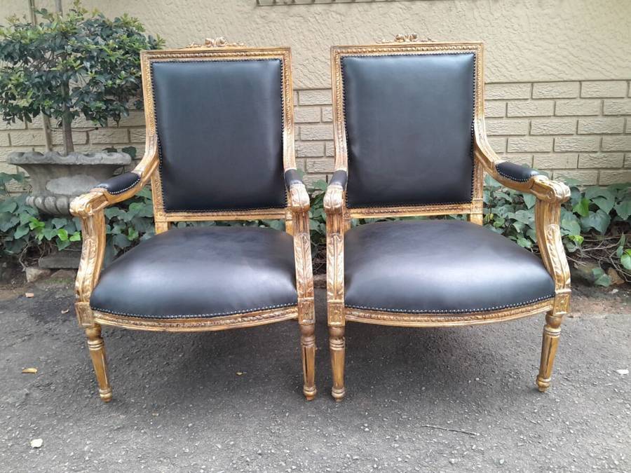A 20th Century French Style Pair of Carved Gilt-Wood Arm Chairs Upholstered in Black Leather