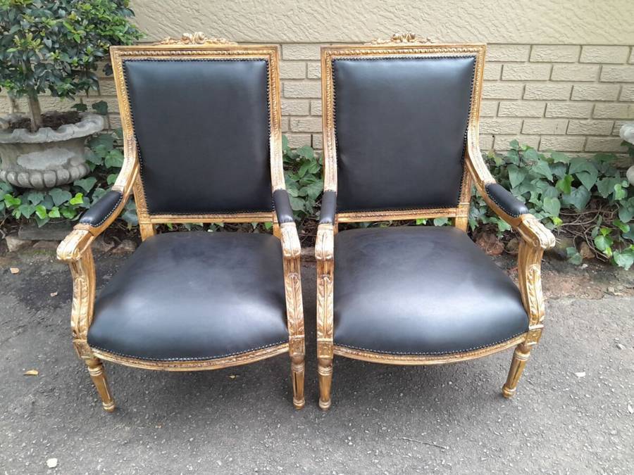 A 20th Century French Style Pair of Carved Gilt-Wood Arm Chairs Upholstered in Black Leather
