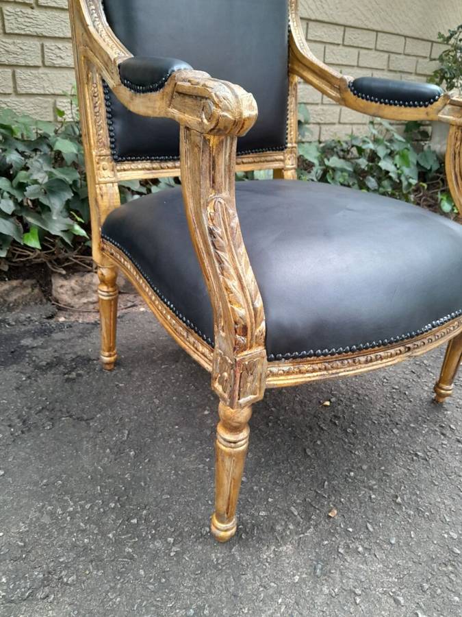 A 20th Century French Style Pair of Carved Gilt-Wood Arm Chairs Upholstered in Black Leather