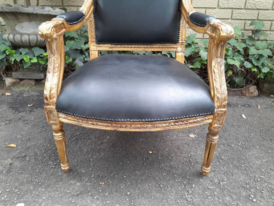 A 20th Century French Style Pair of Carved Gilt-Wood Arm Chairs Upholstered in Black Leather