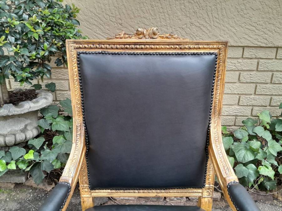 A 20th Century French Style Pair of Carved Gilt-Wood Arm Chairs Upholstered in Black Leather