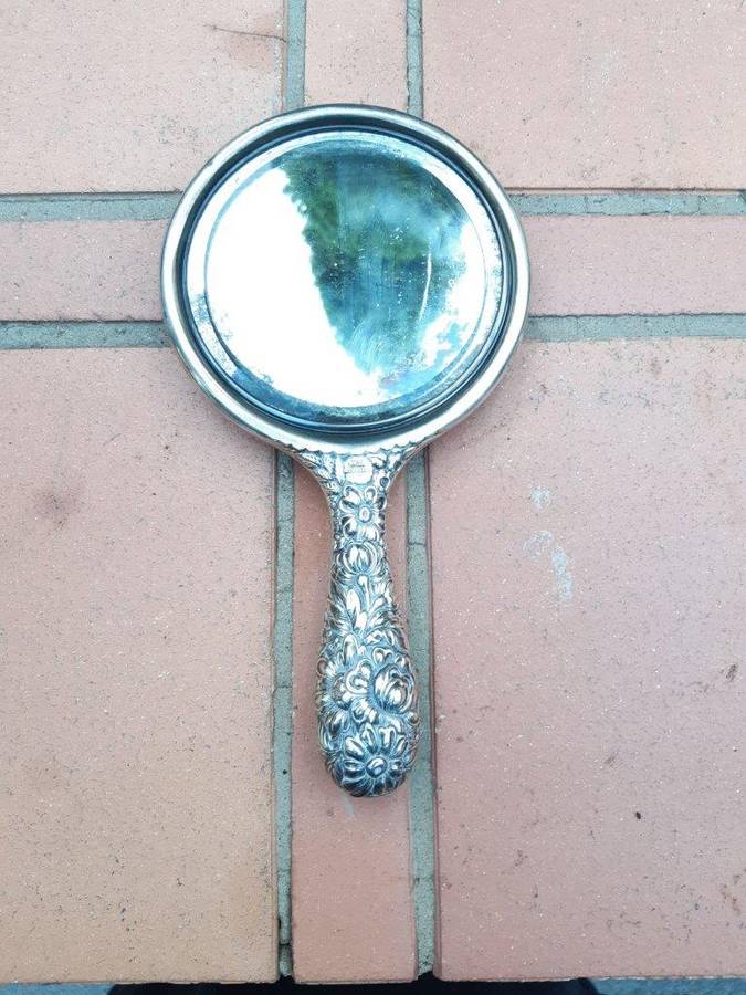 An Antique Repoussé Sterling Silver Hand Held Mirror with signed initials "HDD"