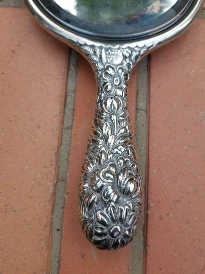 An Antique Repoussé Sterling Silver Hand Held Mirror with signed initials "HDD"