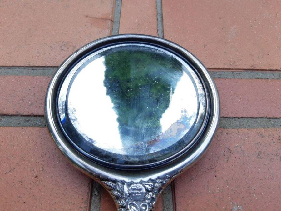 An Antique Repoussé Sterling Silver Hand Held Mirror with signed initials "HDD"