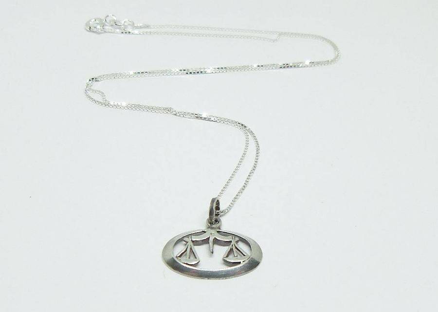 A vintage sterling silver Libra Zodiac sign pendant with a sterling silver necklace