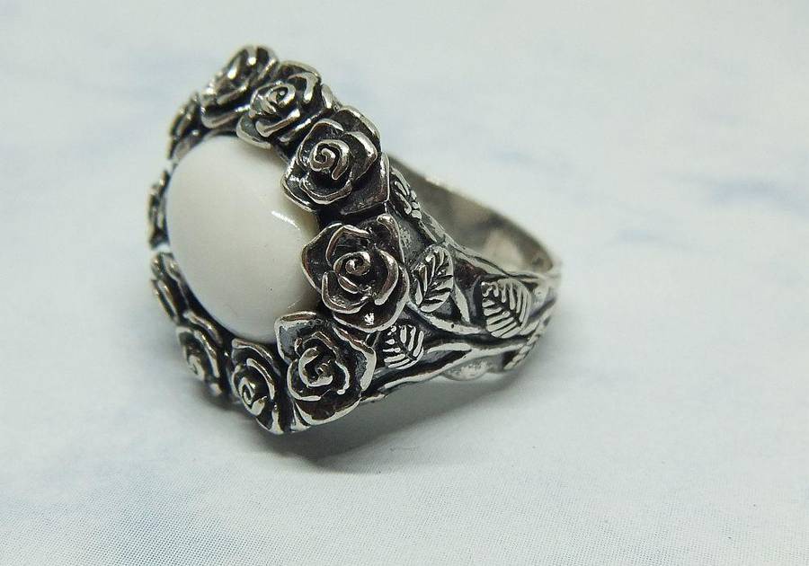 A STUNNING VINTAGE SOLID STERLING SILVER RING WITH WHITE CABOCHON STONE INSET AND ROSE DETAIL