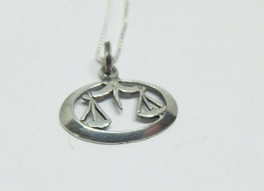 A vintage sterling silver Libra Zodiac sign pendant with a sterling silver necklace