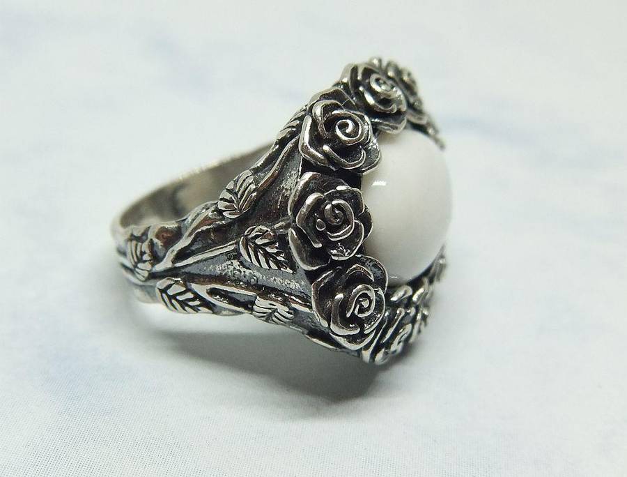A STUNNING VINTAGE SOLID STERLING SILVER RING WITH WHITE CABOCHON STONE INSET AND ROSE DETAIL