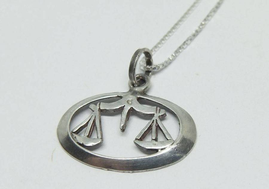 A vintage sterling silver Libra Zodiac sign pendant with a sterling silver necklace