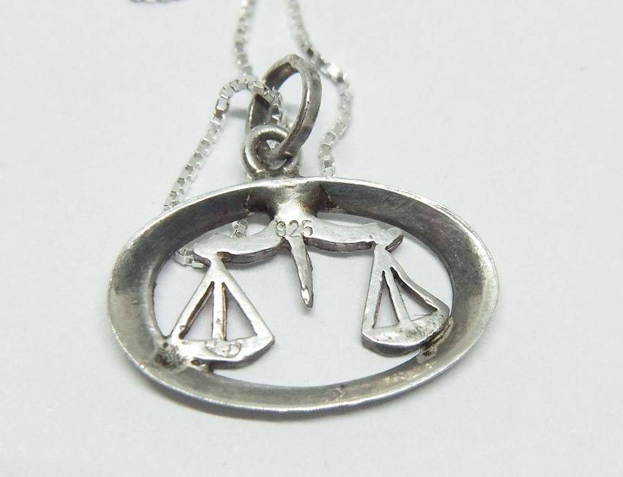 A vintage sterling silver Libra Zodiac sign pendant with a sterling silver necklace