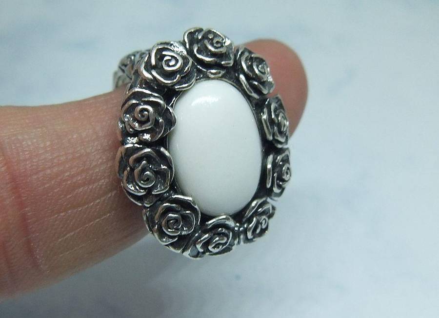 A STUNNING VINTAGE SOLID STERLING SILVER RING WITH WHITE CABOCHON STONE INSET AND ROSE DETAIL