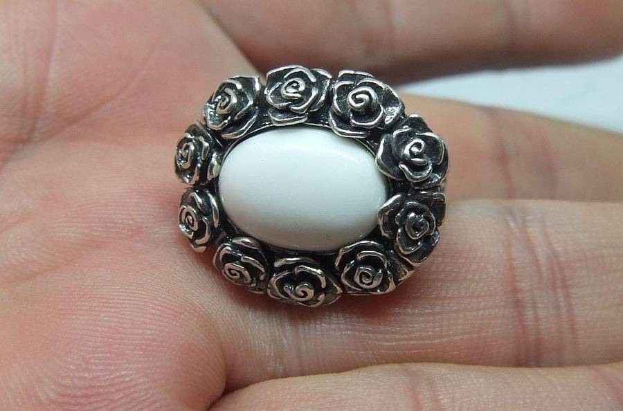 A STUNNING VINTAGE SOLID STERLING SILVER RING WITH WHITE CABOCHON STONE INSET AND ROSE DETAIL
