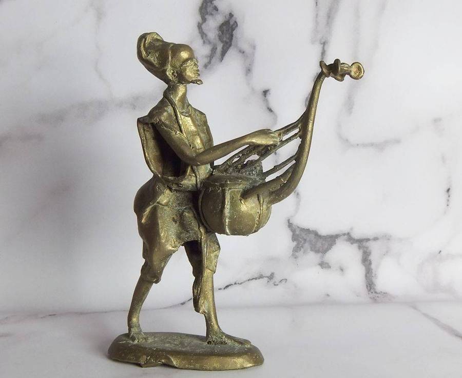 A rare mid 20th century African solid bronze statue of a tribesman with a traditional instrument