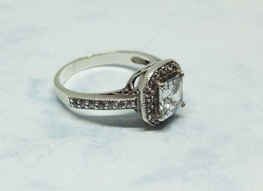 AN ENGAGEMENT STYLE SOLID STERLING SILVER RING SET WITH FACETED CZ STONES