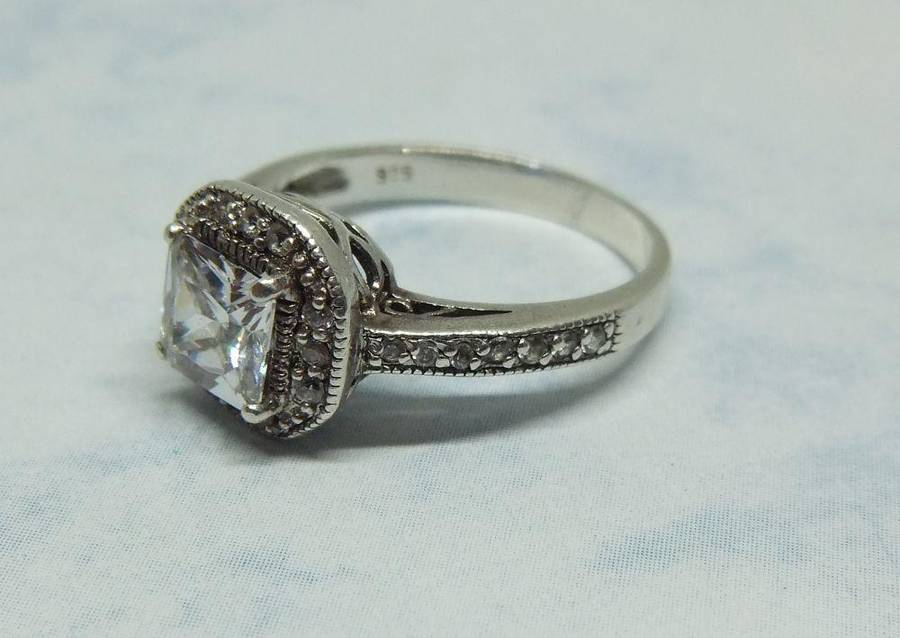 AN ENGAGEMENT STYLE SOLID STERLING SILVER RING SET WITH FACETED CZ STONES