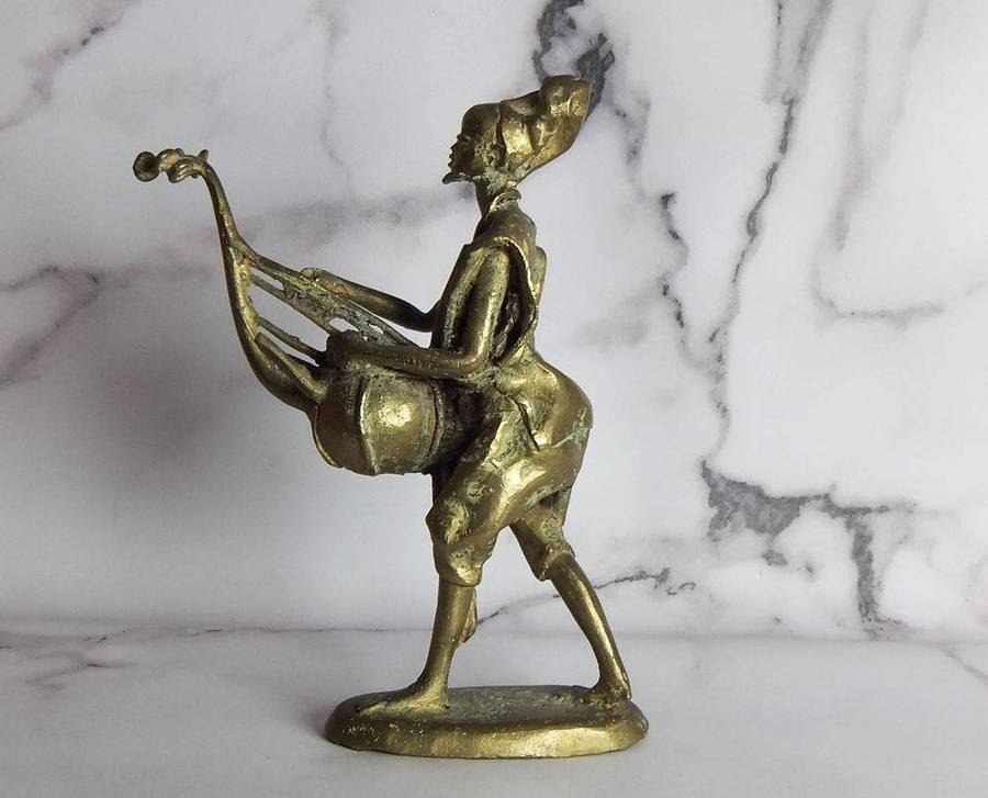 A rare mid 20th century African solid bronze statue of a tribesman with a traditional instrument
