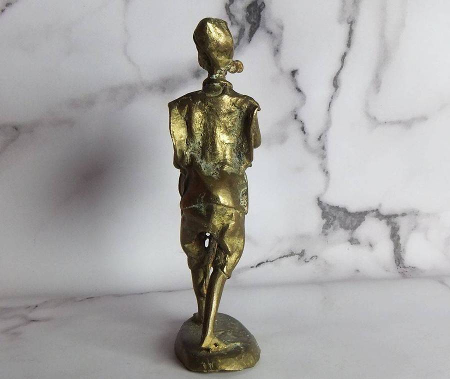 A rare mid 20th century African solid bronze statue of a tribesman with a traditional instrument