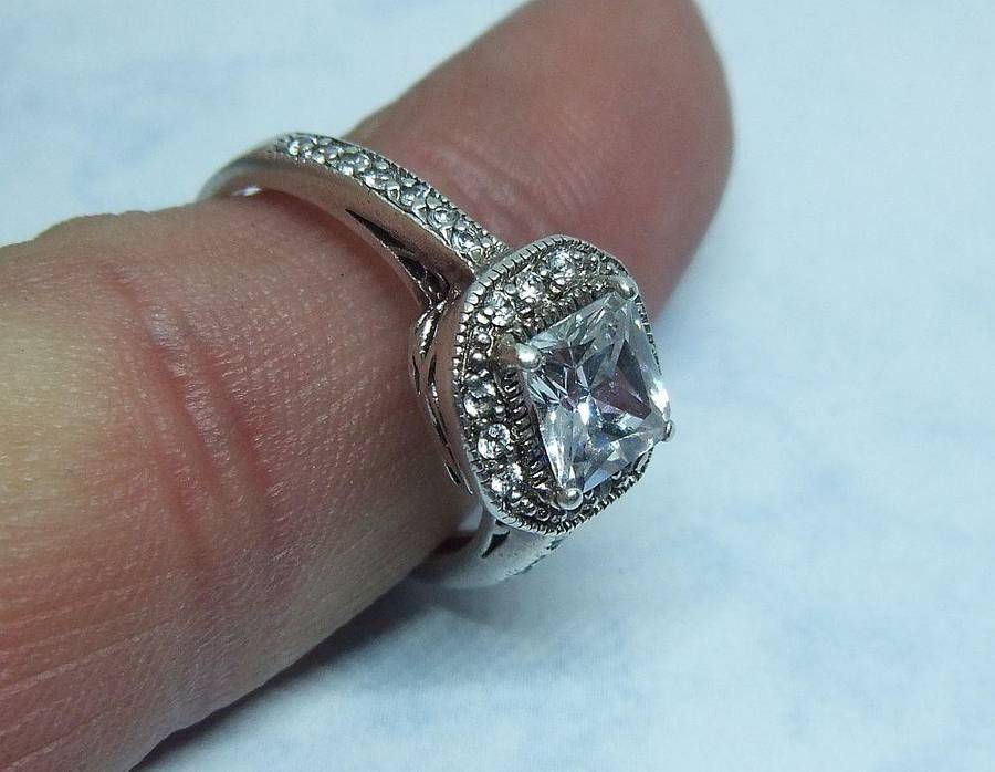 AN ENGAGEMENT STYLE SOLID STERLING SILVER RING SET WITH FACETED CZ STONES