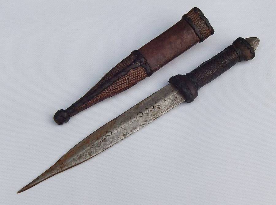 A rare antique North African Tuareg tribal dagger with leather sheath and handle