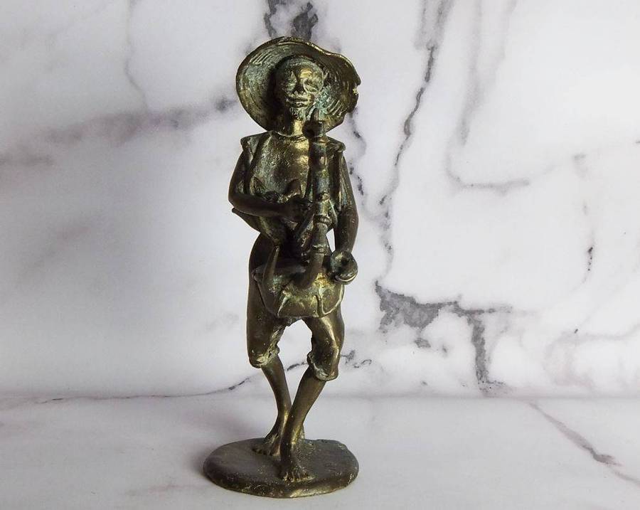 A rare mid 20th century African solid bronze statue of a tribesman with a traditional instrument