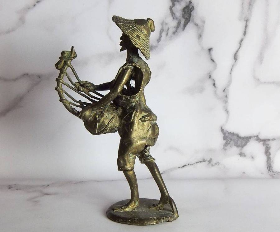 A rare mid 20th century African solid bronze statue of a tribesman with a traditional instrument