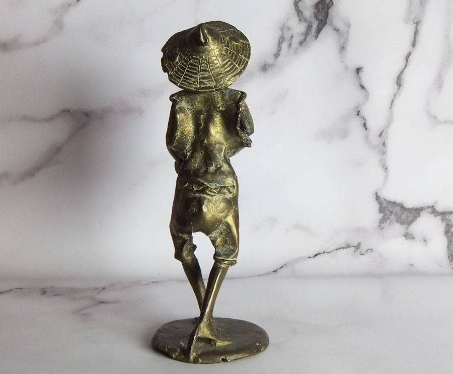 A rare mid 20th century African solid bronze statue of a tribesman with a traditional instrument