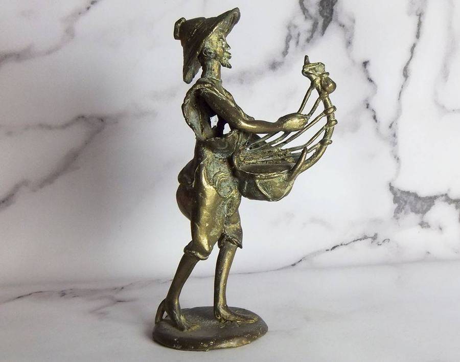 A rare mid 20th century African solid bronze statue of a tribesman with a traditional instrument