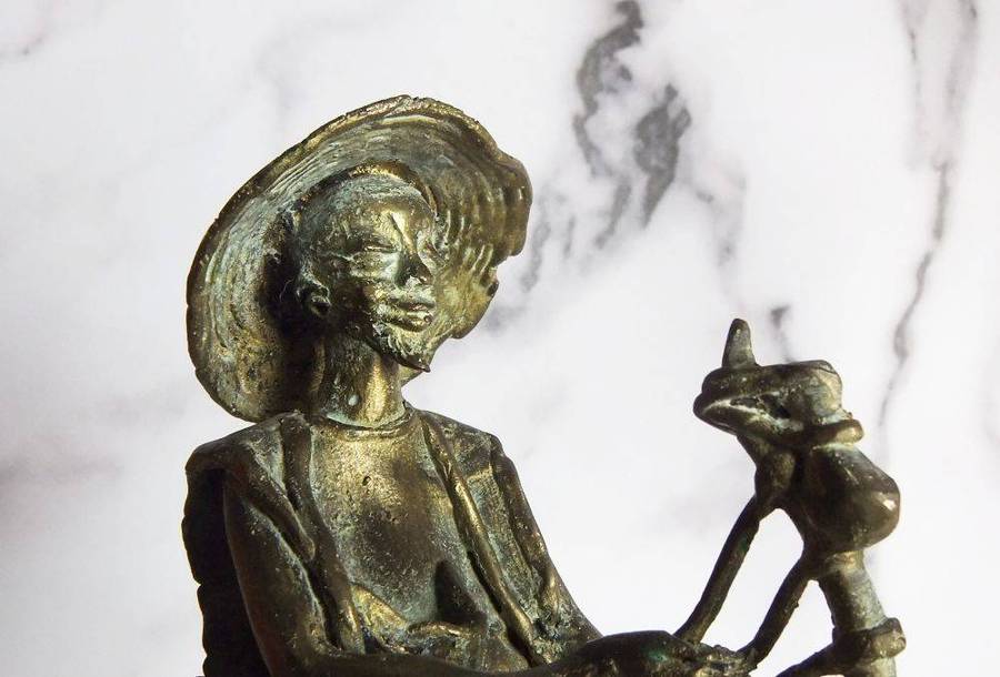 A rare mid 20th century African solid bronze statue of a tribesman with a traditional instrument