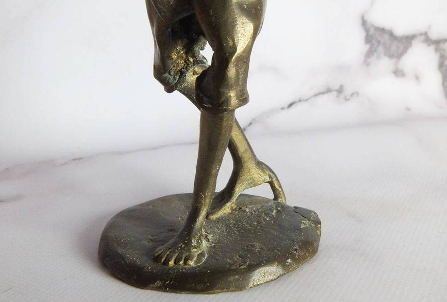 A rare mid 20th century African solid bronze statue of a tribesman with a traditional instrument