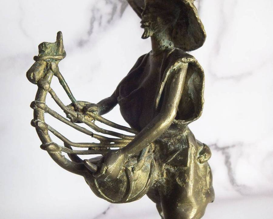 A rare mid 20th century African solid bronze statue of a tribesman with a traditional instrument