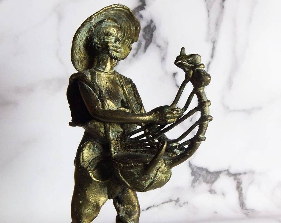 A rare mid 20th century African solid bronze statue of a tribesman with a traditional instrument