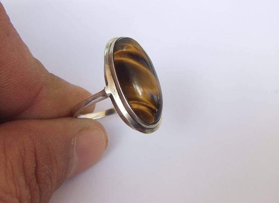 AN ART DECO STYLE VINTAGE STERLING SILVER RING SET WITH A CABOCHON GENUINE TIGERS EYE STONE
