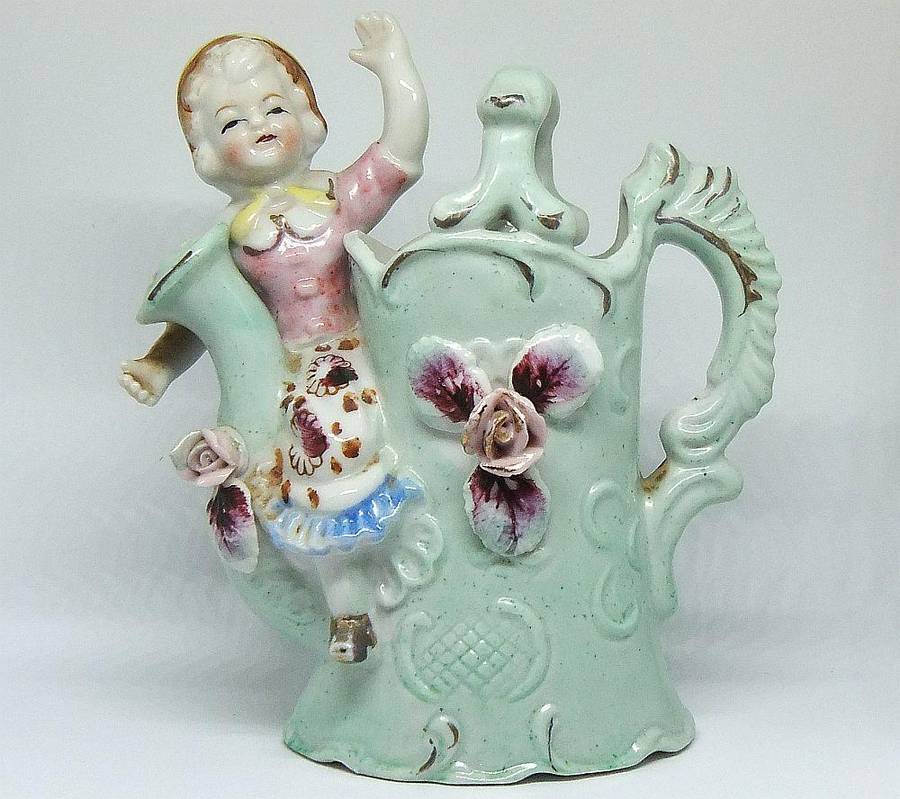 A RATHER KITSCH VINTAGE GIRL SITTING ON A WATERING CAN FIGURINE FLOWER POT IN GOOD CONDITION !!