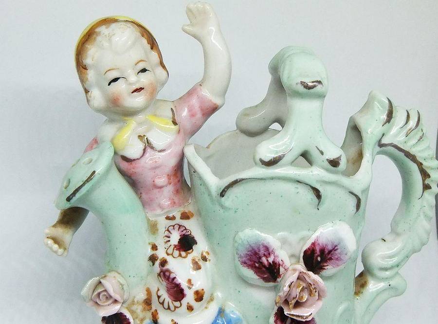 A RATHER KITSCH VINTAGE GIRL SITTING ON A WATERING CAN FIGURINE FLOWER POT IN GOOD CONDITION !!
