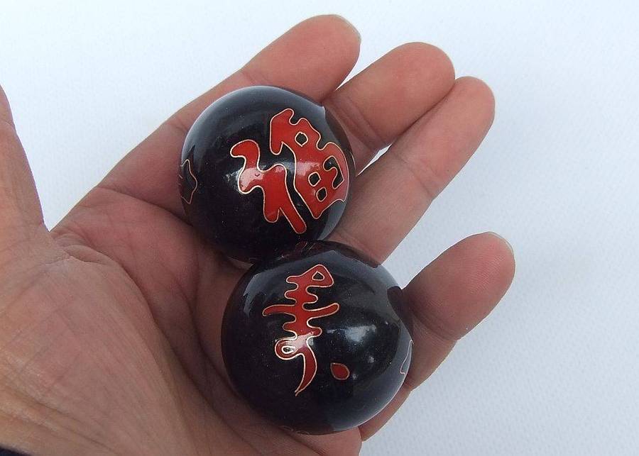 A pair of vintage Chinese iron chime balls with enamel decoration in original box