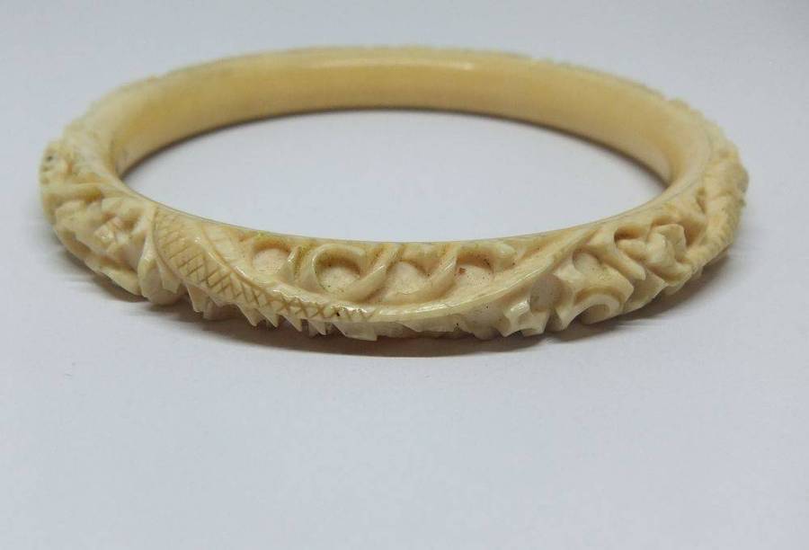 An antique 1920`s Chinese carved bone bangle with Dragon motif