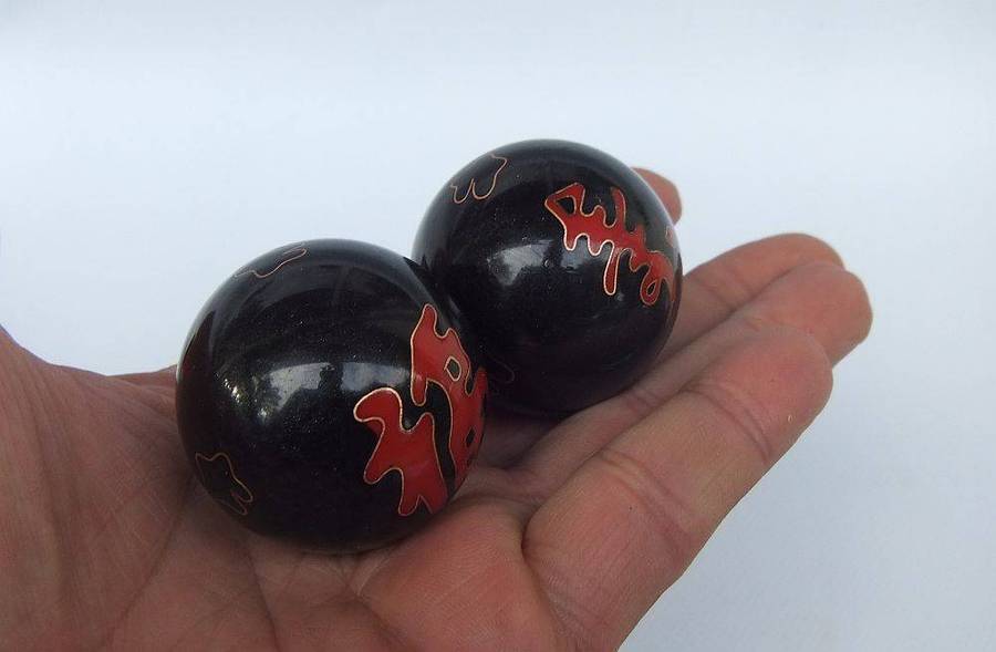 A pair of vintage Chinese iron chime balls with enamel decoration in original box