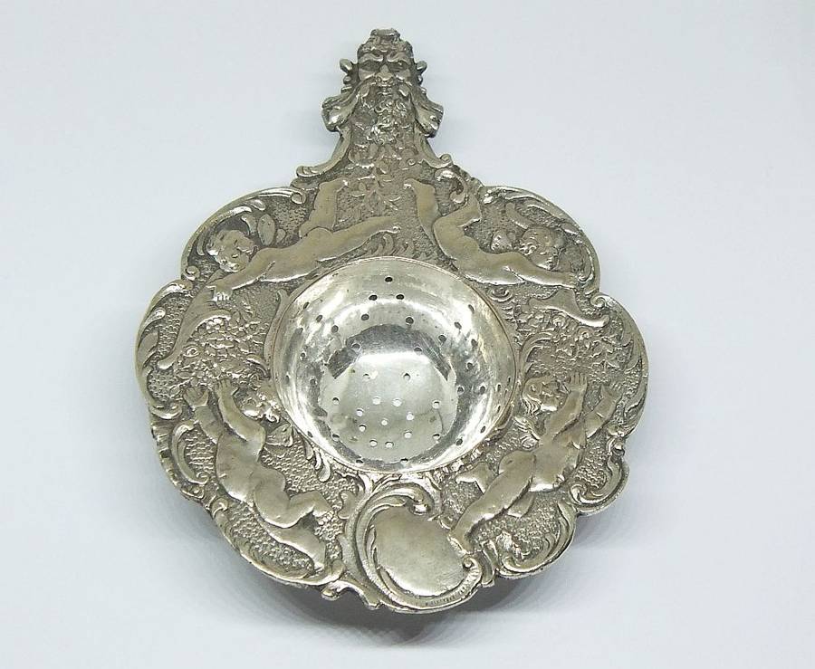 WOW !! A BEAUTIFUL ANTIQUE TEA STRAINER DECORATED WITH CHERUBS STAMPED WITH UNKNOWN MARKINGS