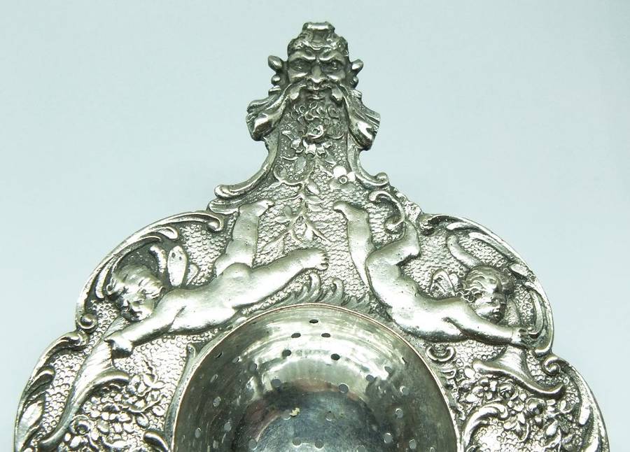 WOW !! A BEAUTIFUL ANTIQUE TEA STRAINER DECORATED WITH CHERUBS STAMPED WITH UNKNOWN MARKINGS