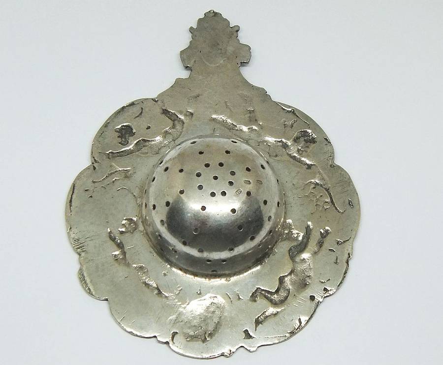 WOW !! A BEAUTIFUL ANTIQUE TEA STRAINER DECORATED WITH CHERUBS STAMPED WITH UNKNOWN MARKINGS