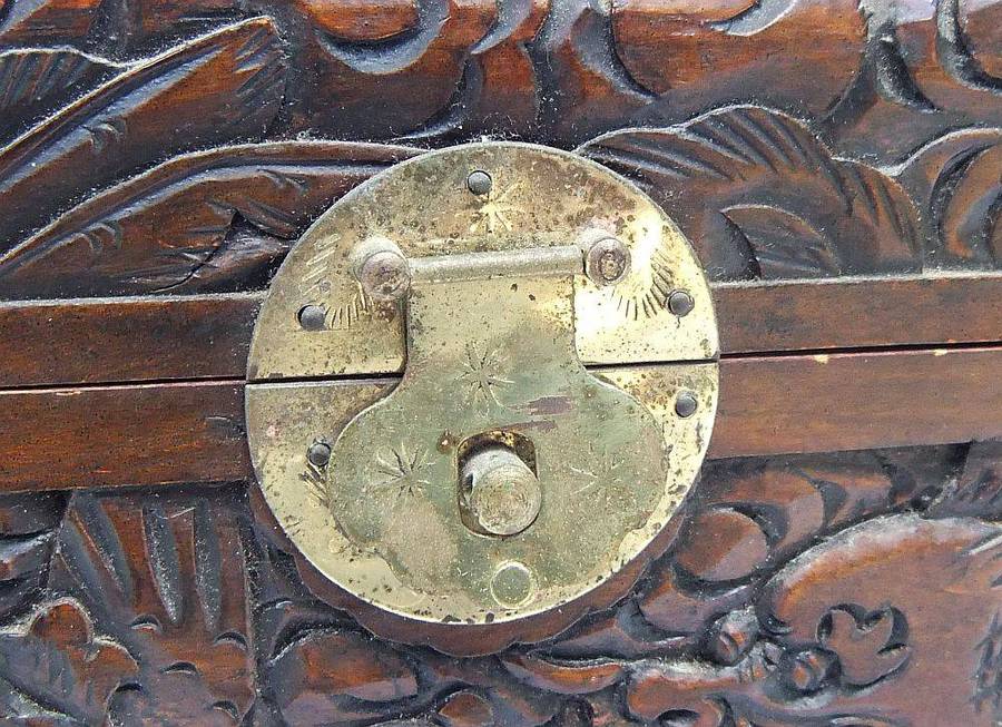 An old Chinese carved wood jewelry box with detailed Dragon and birds decoration