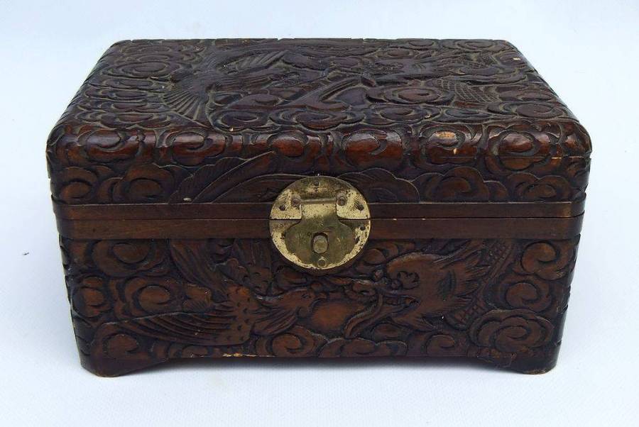 An old Chinese carved wood jewelry box with detailed Dragon and birds decoration