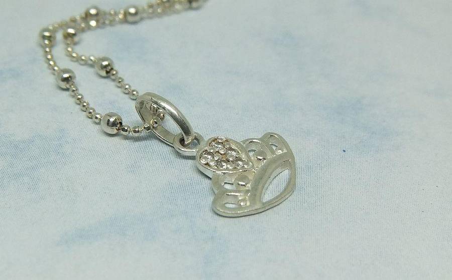A SOLID STERLING SILVER "BALL" NECKLACE WITH A STERLING SILVER CROWN SHAPED PENDANT