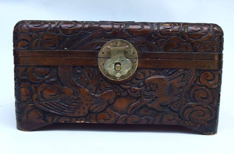An old Chinese carved wood jewelry box with detailed Dragon and birds decoration